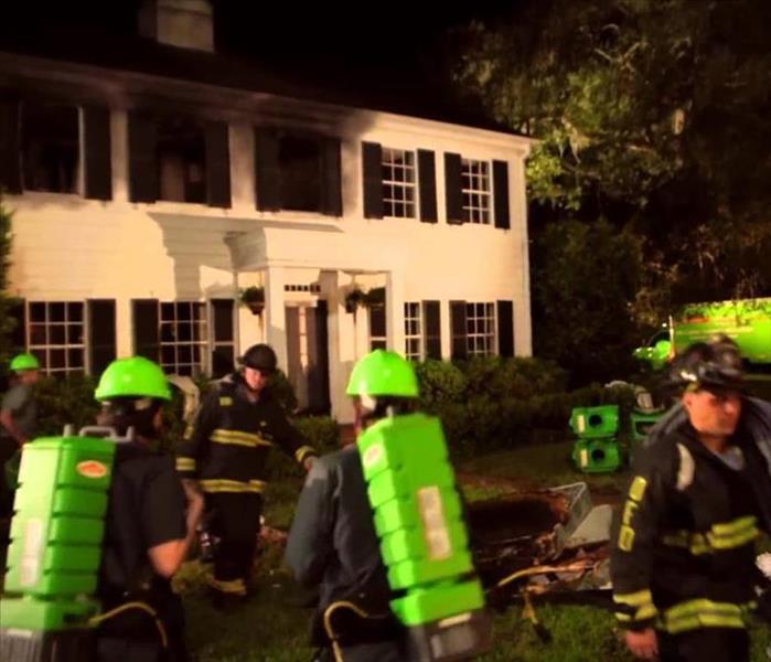SERVPRO crew arriving at a fire as firefighters leave